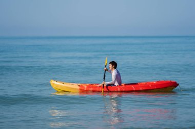 Denizde kano süren bir adam.