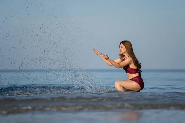 Wesoła Młoda Kobieta Kostiumie Kąpielowym Bawiąca Się Wodą Plaży Morskiej — Zdjęcie stockowe