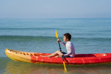 Denizde kano süren bir adam.