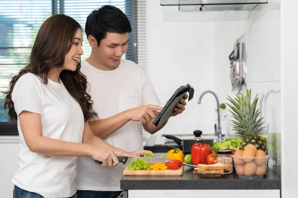 Mutfaktaki Tablet Bilgisayarın Tarifine Göre Çiftler Yemek Pişiriyor Sebze Hazırlıyorlar — Stok fotoğraf