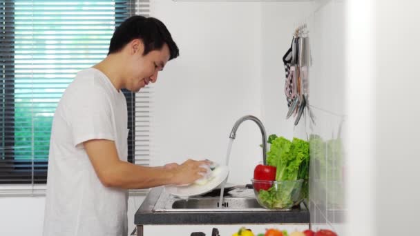 Młody Człowiek Zmywa Naczynia Zlewie Kuchni Domu — Wideo stockowe