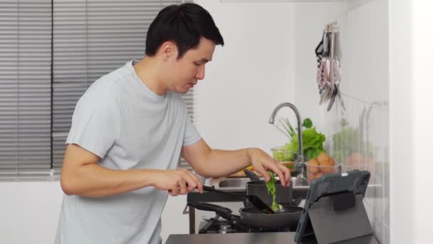 Homem Jovem Cozinhar Preparar Alimentos Acordo Com Uma Receita Computador — Vídeo de Stock