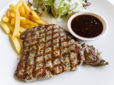 Kızarmış domuz bifteği ve patates kızartması.