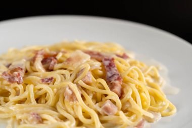 Beyaz tabakta kremalı Carbonara spagettisi.
