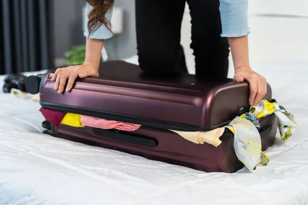 Mujer Tratando Cerrar Maleta Llena Cama — Foto de Stock