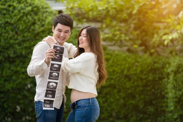 一个快乐的孕妇和她的丈夫正在看婴儿的超声照片 已婚夫妇 — 图库照片