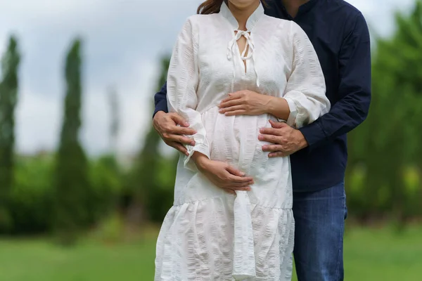 在公园里 亲密的男人拥抱着怀孕的妻子 抚摸着她的肚子 这对新婚夫妇正在等着孩子 — 图库照片
