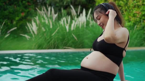 Jovem Grávida Sentada Borda Piscina Enquanto Canta Escuta Música Com — Vídeo de Stock