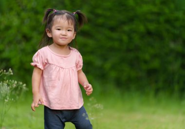 Çimenlikteki küçük mutlu kız