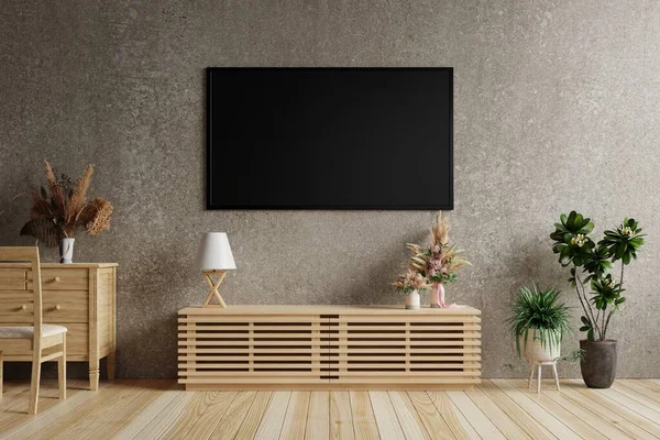 Oturma odasında, üzerinde lambalar ve masanın üzerinde bir vazo çiçek olan koyu beton bir duvarda büyük bir televizyon. Mobilya ve saksılarla süslenmiş.