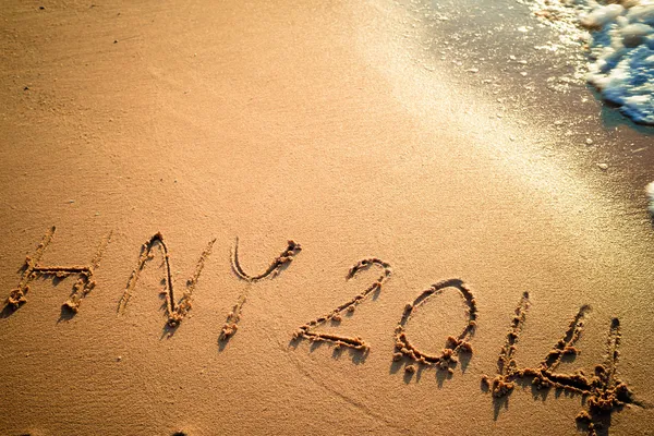 Schrijven gelukkig nieuw jaar 2014 op het strand in thailand — Stockfoto