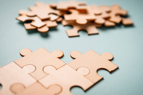Wooden puzzles jigsaw solving problems in business. Innovation and teamwork in the company with copy space.