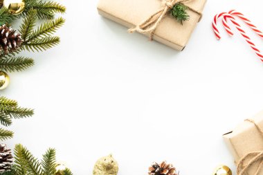 Hediye kutusuyla güzel bir Noel arkaplanı, beyaz arka planda çam kozalağı ile süslenmiş. Kopyalama alanı olan üst görünüm, döşeme.