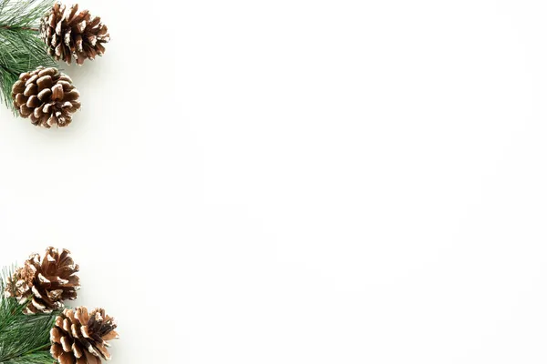 松の枝や松のコーンなどのクリスマスの装飾が施された白いテーブル メリークリスマスと幸せな新年のコンセプト コピースペース フラットレイ付きのトップビュー — ストック写真