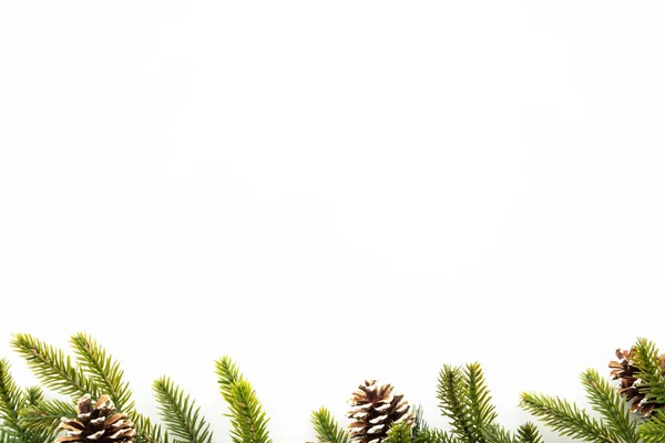 松の枝や松のコーンなどのクリスマスの装飾が施された白いテーブル メリークリスマスと幸せな新年のコンセプト コピースペース フラットレイ付きのトップビュー — ストック写真