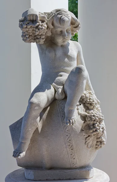 Statua di un bambino seduto su un vaso — Foto Stock