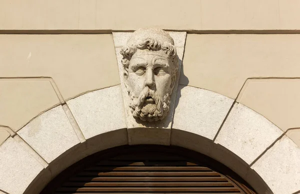 イタリアのトリエステにある店の窓の上に髭の男の頭の大理石の彫刻 — ストック写真