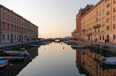 TRIESTE, İtalya - 25 Mart 2022: Günbatımında Canal Grande, sağda Gopcevich sarayı