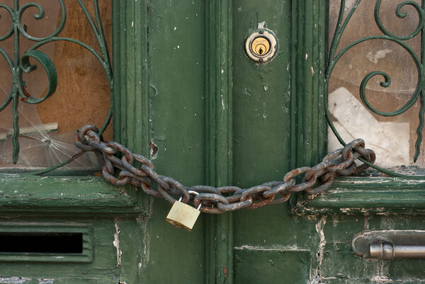 Зеленая дверь с цепью и замком
