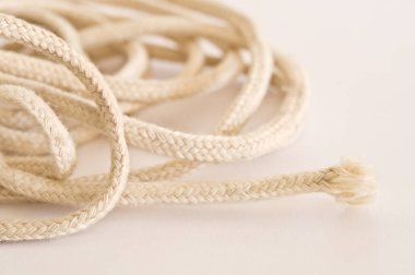 Beyaz arka planda birbirine dolanmış ip. Seçici odak ve alanın sığ derinliği.