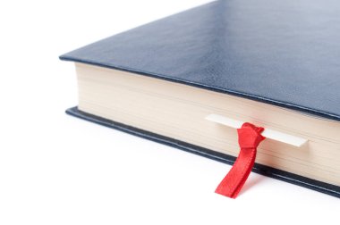 Beyaz arkaplan üzerine kitap ayracı olan bir kitabın yakın çekimi. Seçici odak ve alanın sığ derinliği.