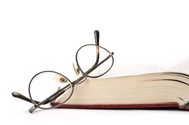 kitap ve beyaz zemin üzerine gözlük.