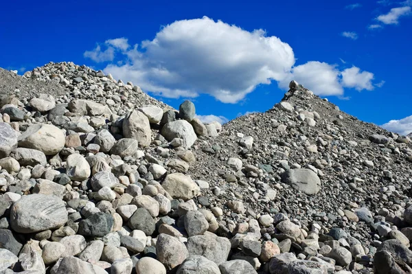蓝天和蓝云衬托下的石子和砾石堆 — 图库照片