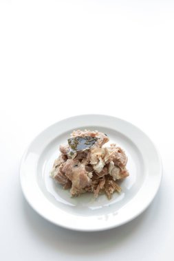 Beyaz bir tabakta ağır ateşte pişmiş domuz eti.