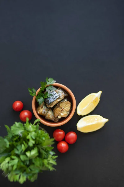 Makrela obecná na kousky na hliněném talíři. Černé pozadí a zelenina. Koncept zdravé stravy — Stock fotografie