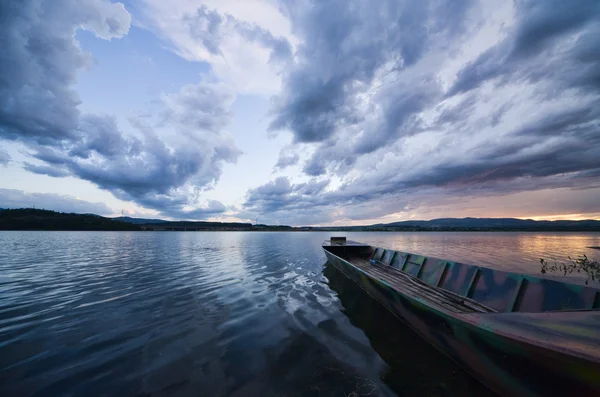 暴风雨的乌云，一条船在湖上 — 图库照片