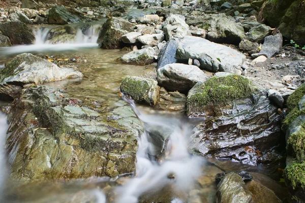 Grus eller stenar i creek eller ström strömmande vatten — Stockfoto