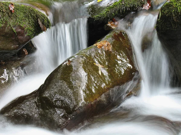 Галька или камни в ручье или ручье текучей воды — стоковое фото