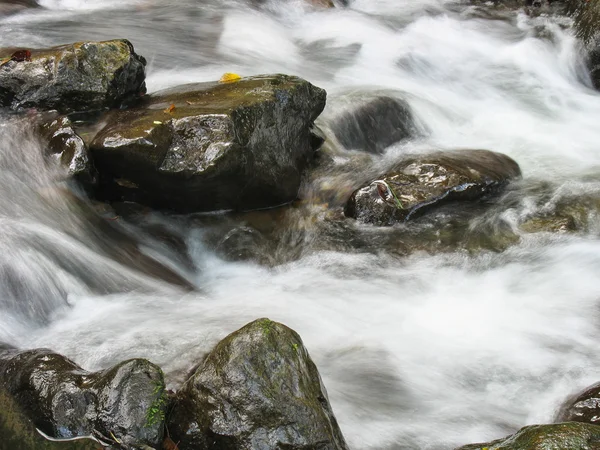Pebbles or rocks in creek or stream flowing water Stock Image