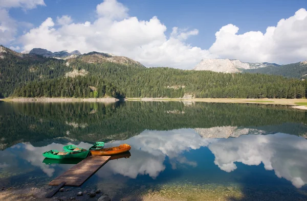 Відображення в гладкій воді гірських озер і човнів — стокове фото