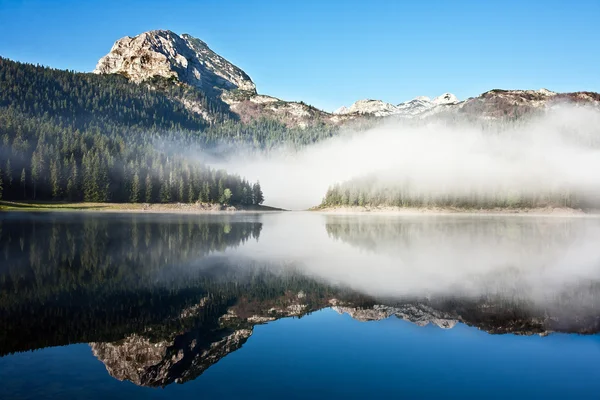Lac de montagne brumeux avec ciel bleu — Photo