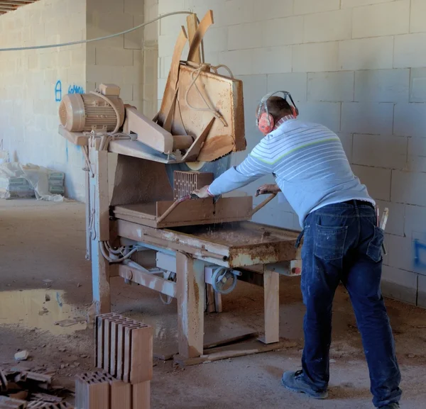 Pracownik cięcia cegły z mocy Piła — Zdjęcie stockowe
