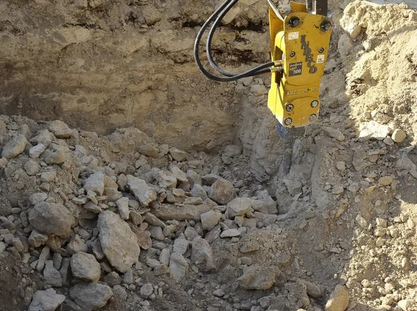 Excavator with Hydraulic hammer demolishes stone — Stock Photo, Image