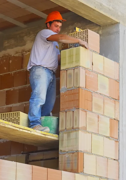 Bouwvakker voert een externe metselaar muur — Stockfoto