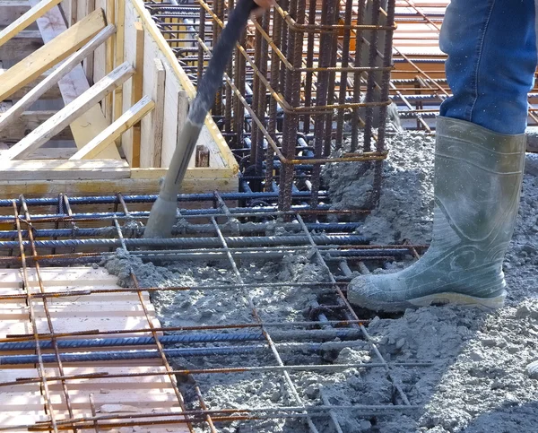 Worker with vibrator machine compacting poured concrete — Stock Photo, Image