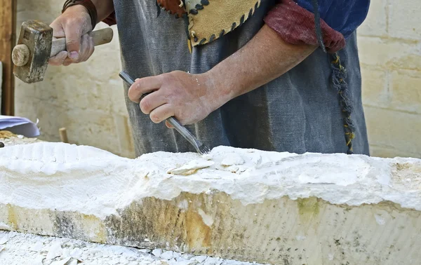 Stenhuggare som arbetar på en kub av sandsten — Stockfoto