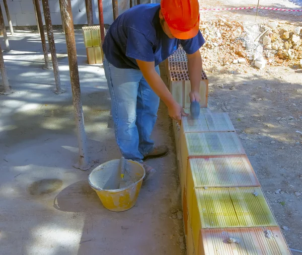 Trabalhador da construção executa uma parede externa de pedreiro — Fotografia de Stock