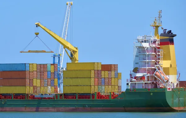 Contenitori di carico gru su una nave in un porto industriale — Foto Stock