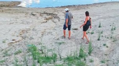 Minervino Murge, Puglia 'da bulunan yapay bir rezervuar olan Locone Gölü' nü ziyaret eden iki turistin insansız hava aracı görüntüsü. İtalya