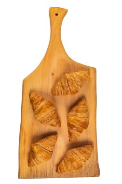 Tahta masada taze aromalı kruvasan, beyaz üzerine izole edilmiş.