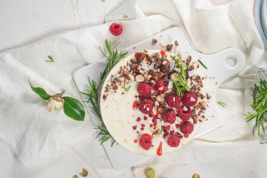 Mutfakta ahududu, çikolata, fındık ve biberiye yapraklı cheesecake.