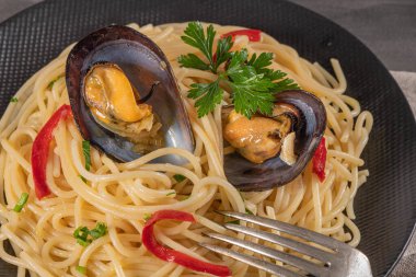 Kabuklu midyeli, biberli ve maydanozlu makarna. Deniz yemeği.