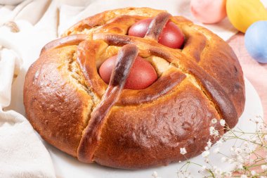 Portekiz geleneksel paskalya pastası. Paskalya masasında yumurtalı folar. Çiçekler ve renkli boyanmış yumurtalar.