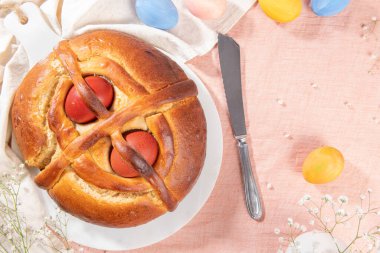 Portekiz geleneksel paskalya pastası. Paskalya masasında yumurtalı folar. Çiçekler ve renkli boyanmış yumurtalar.