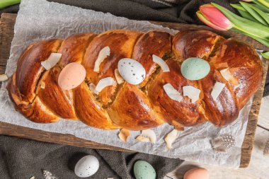 Portekiz geleneksel paskalya pastası. Paskalya masasında yumurtalı folar. Çiçekli laleler, renkli boyanmış yumurtalar ve tüyler.