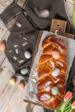 Portekiz geleneksel paskalya pastası. Paskalya masasında yumurtalı folar. Çiçekli laleler, renkli boyanmış yumurtalar ve tüyler.